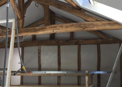 Aménagement de combles avec structure bois apparente et pose de plaques de plâtre sous rampants avant finitions.